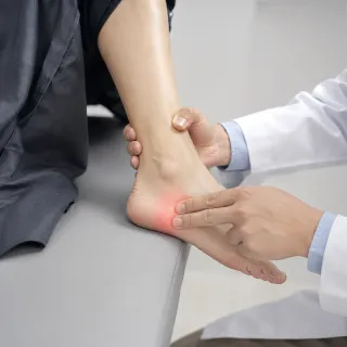 Doctor Examining Patient Heel Pain and Inflammation - Orthopedic Stock Photo