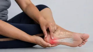 Patient Pointing to Heel Pain Caused by Plantar Fasciitis - Medical Stock Photo