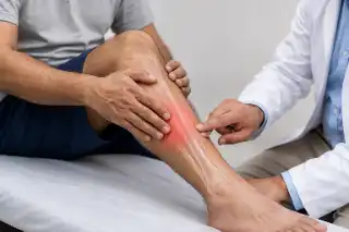 Doctor Examining Patient With Localized Bone Pain in Lower Leg Stock Photo