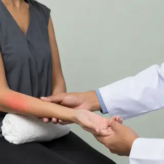 Doctor Examining Patient Medial Elbow in Clinic - Clinical Orthopedics Photo