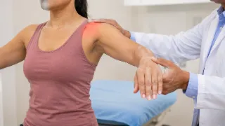 Doctor Examining Female Patient Shoulder During Orthopedic Rotator Cuff Test