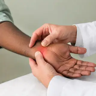 Physician Performing Carpal Tunnel Syndrome Examination on Patient Wrist - Clinical Stock Photo
