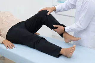 Neurologist Checking Lower Limb Strength and Reflexes in Patient