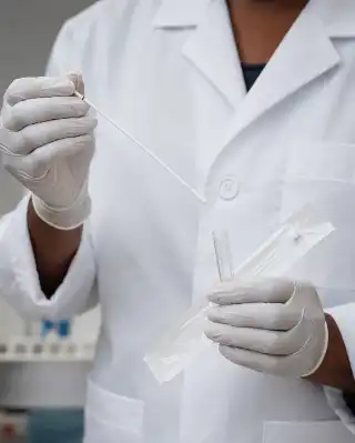 Medical Professional Handling Sterile Swab and Collection Vial in Laboratory