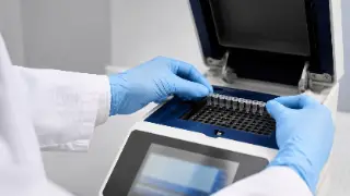 Laboratory Technician Loading PCR Thermal Cycler with Microtubes